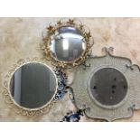 A circular mirror in scroll embossed metal frame with wrought iron scrolled border; a convex