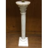 A tall carved alabaster tablelamp with tapering fluted column having scrolled capitals, raised on