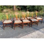 A set of eight Sheraton style mahogany dining chairs, the moulded arched backs framing waisted