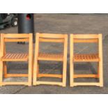 A set of three folding hardwood garden chairs with slatted seats and shaped backs. (3)