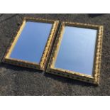 A pair of modern rectangular mirrors in pierced gilt scrolled frames with leaf mouldings and
