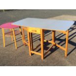 A circular formica topped table on angled rectangular tapering legs joined by platform stretcher;