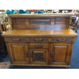 A late Victorian oak sideboard, with moulded shelf on fluted turned columns above a panelled back,