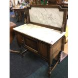 A George VI oak washstand with shaped framed marble panel above slab top, having panelled cupboard