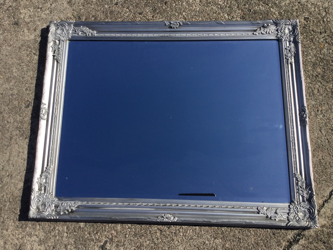 A modern rectangular mirror with bevelled plate in foliate moulded silvered frame. (36.75in x 28.