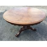 A circular George IV mahogany breakfast table, the moulded top with scalloped apron supported and