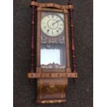 A Victorian wallclock, the walnut case inlaid with geometric banding having carved crest above a