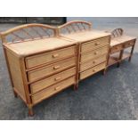 A pair of cane bedside cabinets with arched backs and tray tops above drawers, the legs united by