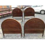 A pair of 3ft Edwardian mahogany beds with arched moulded headboards & tailboards, raised on
