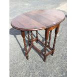 An oval oak drop-leaf table, the moulded top on barleytwist legs joined by rectangular stretchers,