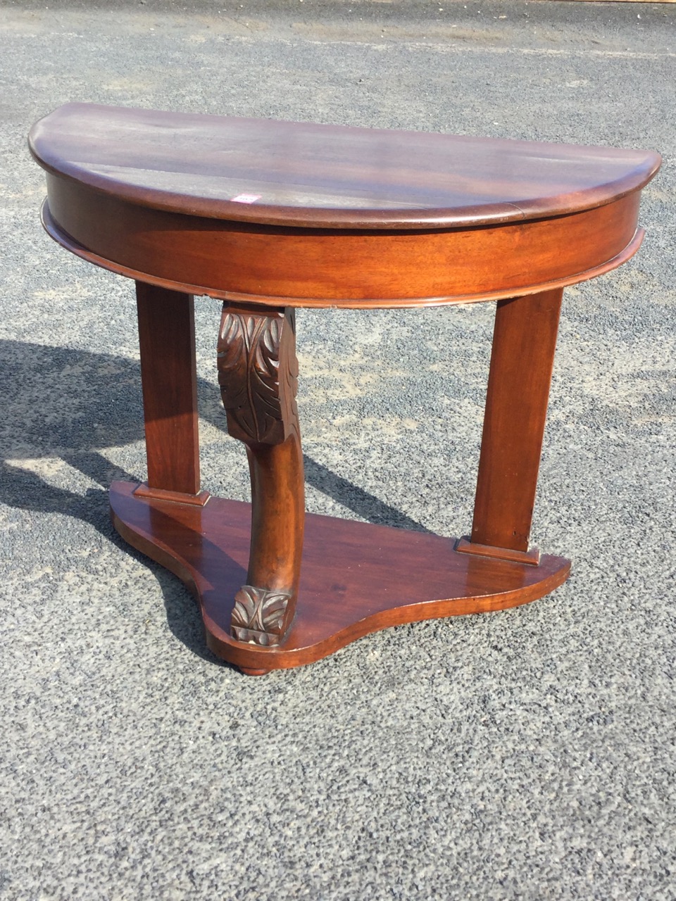 A Victorian mahogany hall table of D shaped outline, having plain frieze supported on acanthus