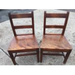 A pair of nineteenth century country fruitwood chairs with bar backs above tapering solid seats,