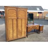 A burr oak bedroom suite with two-door wardrobe, dressing table and bedside cupboard, having