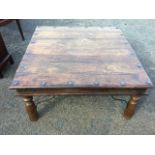 A square hardwood coffee table with iron mounts and channelled frieze, raised on turned legs. (