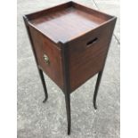 A Georgian mahogany nightstand, the square tray top above a crossbanded cupboard mounted with