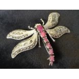 A cased silver dragonfly brooch, the body claw set with oval rubies, the articulated wings with