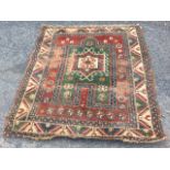 An antique oriental prayer rug woven with central green field having hooked medallion, framed by