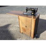 A mahogany cased Singer sewing machine with flip top revealing the works with treadle & electric