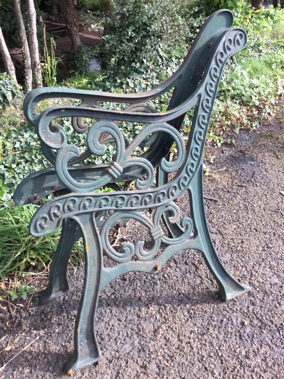 A pair of cast iron bench ends with pierced scrolled decoration on channelled sabre legs. (2)