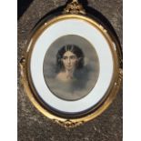 An oval Edwardian bust portrait of a glamorous lady, mounted, and in floral mounted and moulded gilt