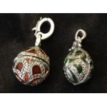 A silver green enamelled egg shaped locket, the hinged container with ribbon style mounts set with