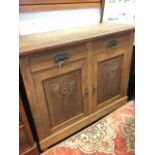 An art nouveau oak sideboard, with moulded rectangular top above two frieze drawers, the cupboards