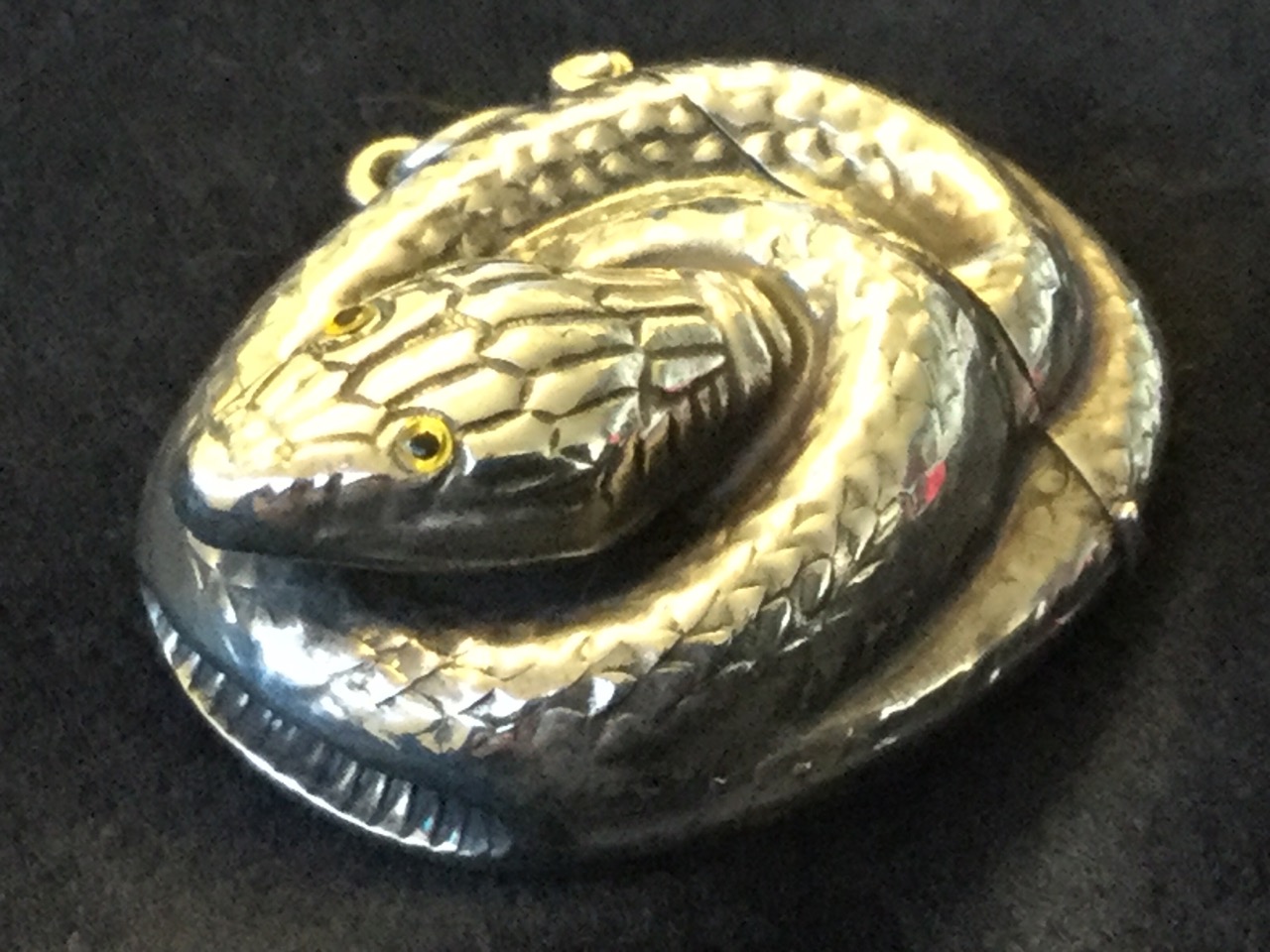 A Sterling silver novelty vesta case modelled as a coiled snake with inlaid eyes, having sprung