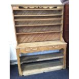 A nineteenth century Irish pine dresser, the rack with shaped apron above three open shelves with