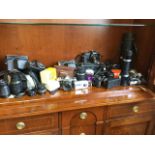 A collection of cameras including Zenit, Pentax, Minolta, Canon, Kodak, Fujifilm, lenses, flash