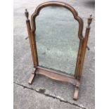 A George II style walnut dressing table mirror, with arched cushion moulded frame on tapering