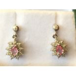 A pair of 9ct gold pink sapphire and diamond drop earrings, with delicate flowerhead ovals suspended
