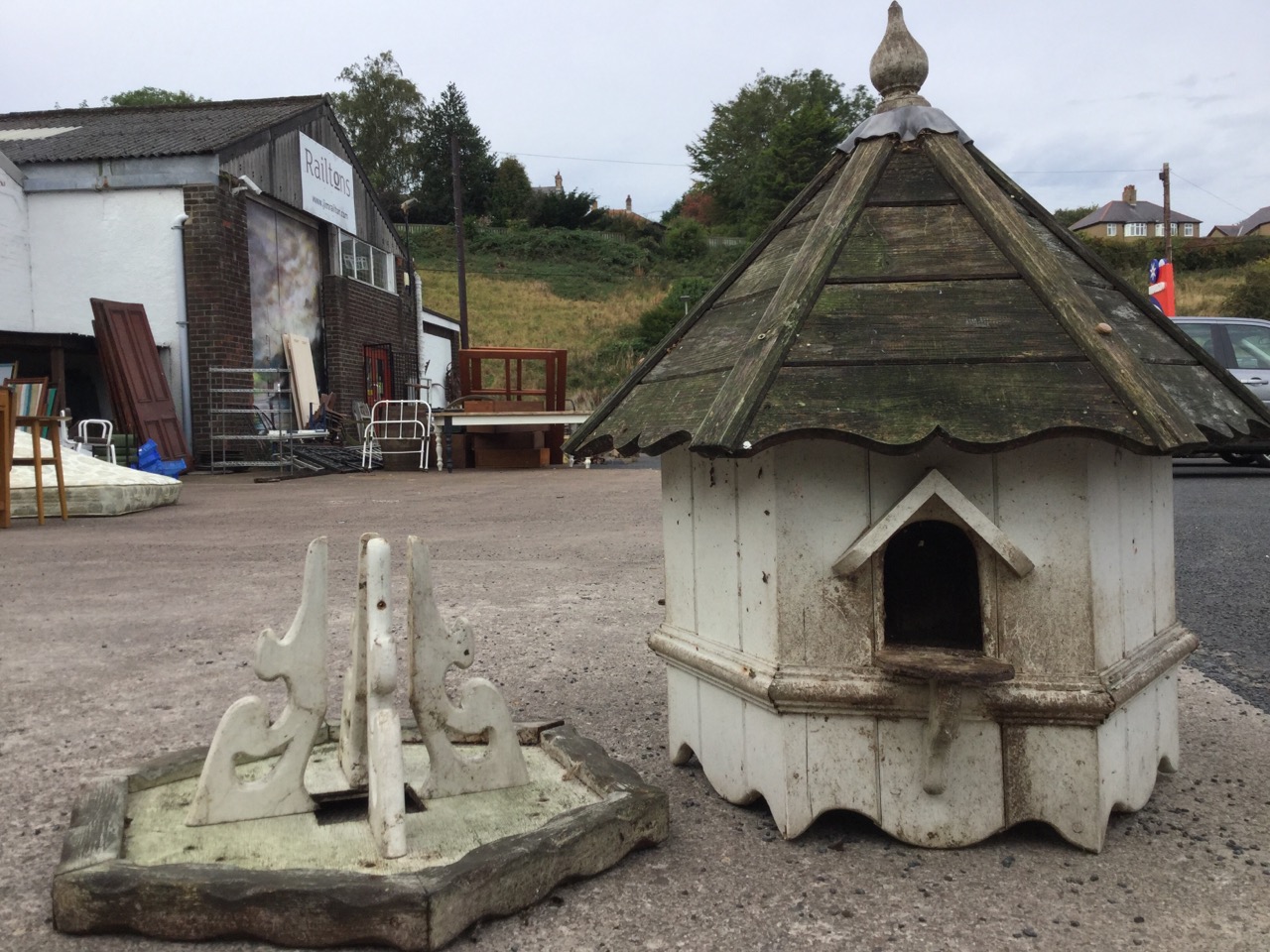 An hexagonal dovecote with turned finial above a pitched boarded roof, having three apertures with