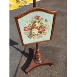 A Victorian mahogany pole screen, with later shield shaped floral tapestry panel on turned column