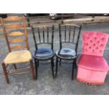 A pair of ebonised bentwood chairs with spindle backs above circular seats; a ladderback chair