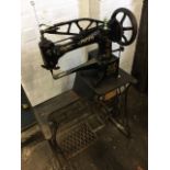 A large working cast iron Singer patcher sewing machine, on treadle stand with rocking needle and