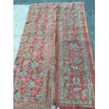 A pair of antique Turkey runners woven with busy red fields of blue, green and charcoal floral
