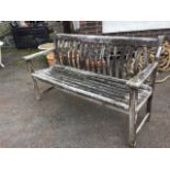 An Alexander Rose hardwood garden bench, with slatted curved back & seat, having tapering platform