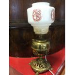 A Victorian brass oil lamp on stand, converted to electricity with milk glass shade, the circular