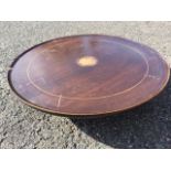 A mahogany lazy susan with circular tray top inlaid with boxwood string and central floral