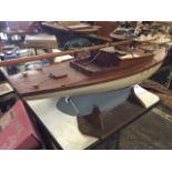 A large early C20th mahogany pond yacht with motorisation, having deep weighted keel on later stand,