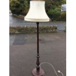 A stained standard lamp with fluted column on chisel scroll carved circular base with three bun