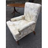 A late Victorian upholstered armchair with rectangular back above padded arms and long sprung seat