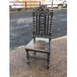 A nineteenth century carved oak hall chair, the pierced back with green man masque above an ivy leaf