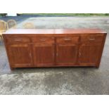 A contemporary hardwood sideboard, the panelled rectangular top above four drawers and four