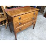 An Edwardian mahogany chest inlaid with boxwood stringing, having three drawers mounted with ring