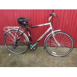 A Raleigh Pioneer MetroLX bicycle with a Rio soft seat, back pannier rack, Shimano gears, helmet,