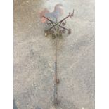 A wrought iron weather vane surmounted by a fretwork bird, the compass points on scrolled