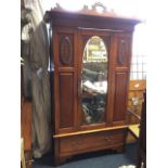 A late Victorian carved mahogany wardrobe with pierced scrolled crest above moulded cornice, the