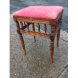 A late Victorian walnut stool with rectangular upholstered seat above frame of gallery spindles,