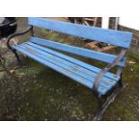 A long cast iron & wood garden bench with painted and bolted slats on heavy cast frame, the ends